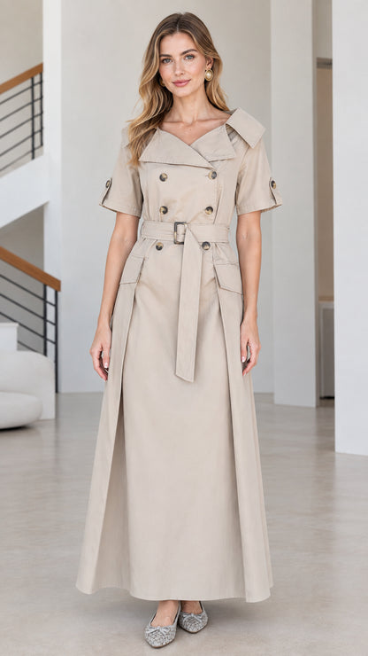 Front view of woman wearing beige double-breasted short-sleeve trench maxi dress with belt