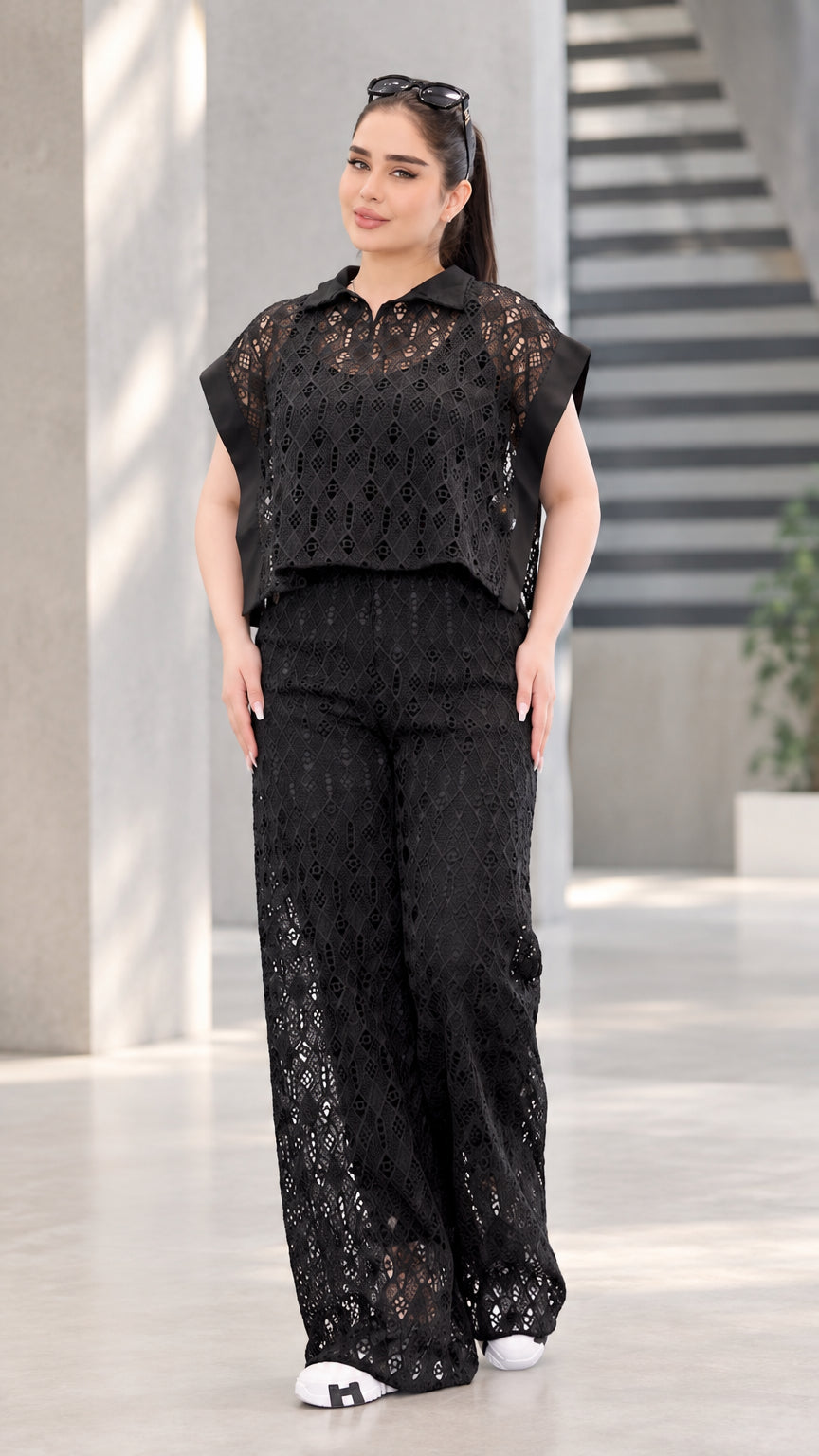 Front full-length view of woman wearing black lace collared top and matching wide-leg pants set