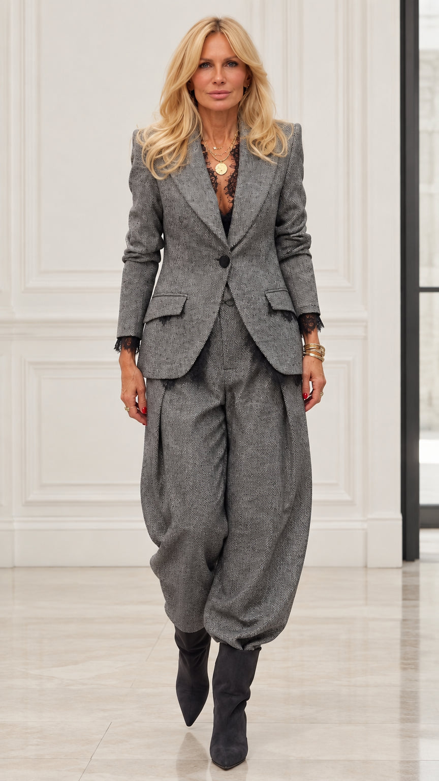 Model wearing Grey herringbone blazer and pleated balloon trousers two-piece suit set with lace cuffs