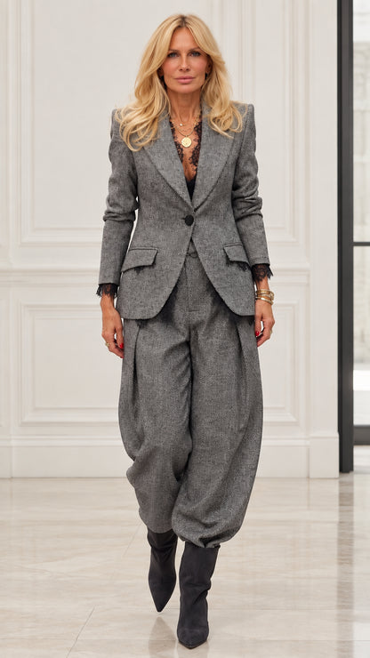 Model wearing Grey herringbone blazer and pleated balloon trousers two-piece suit set with lace cuffs