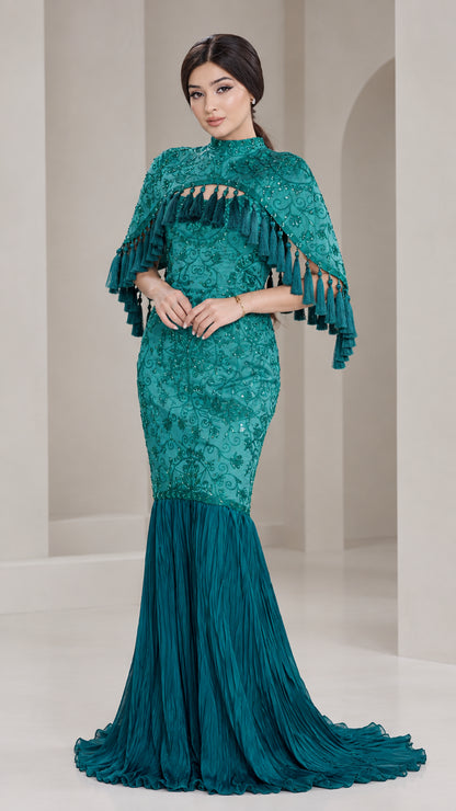 Front view of model wearing Teal Green embroidered cape mermaid gown with tassel trim
