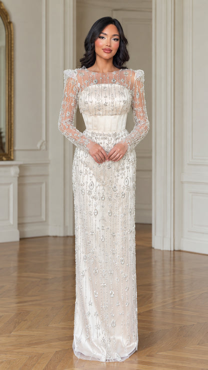 Front view of model wearing ivory beaded long sleeve corset evening gown