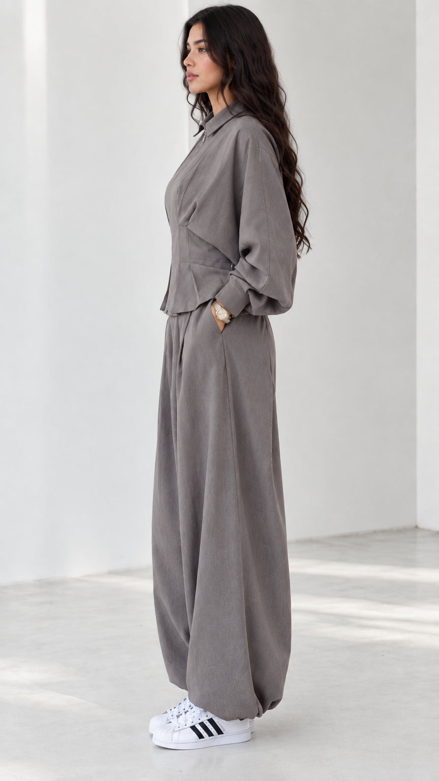 Side view of model wearing grey tailored zip jacket and voluminous trousers set
