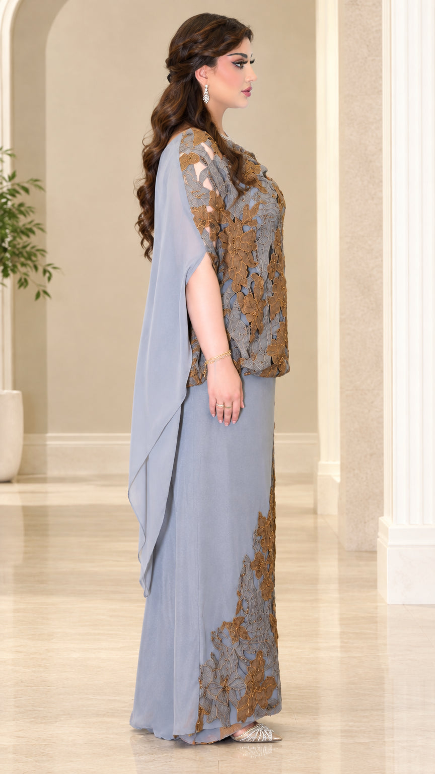 Side profile of dusty blue formal gown with flowing cape overlay
