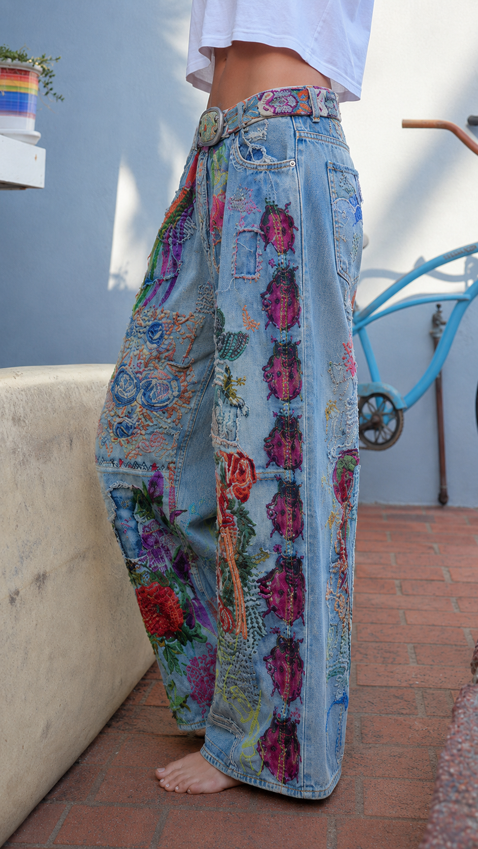 Side view of light blue floral patchwork wide leg jeans with high waist and full-length leg