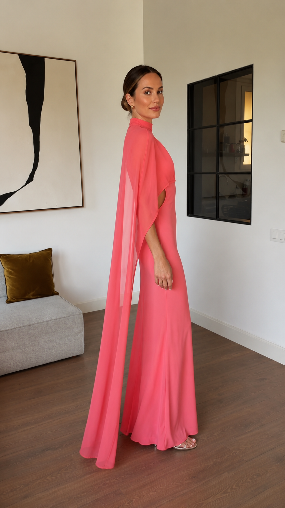 Side view of coral pink floor length gown with flowing cape overlay