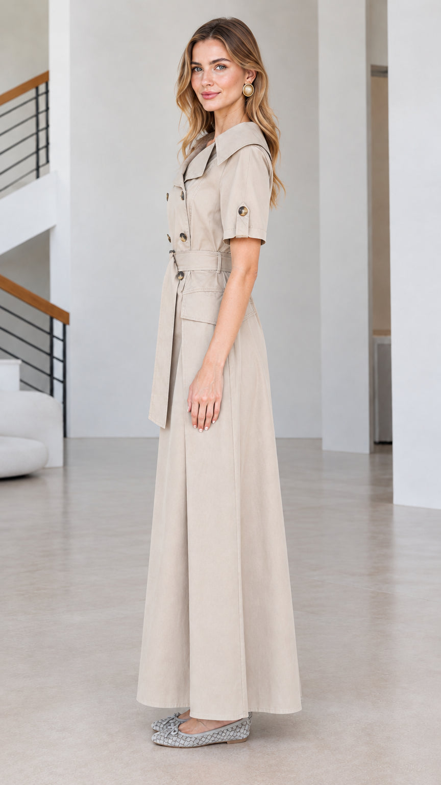 Side view of beige tailored trench maxi dress showing full-length skirt