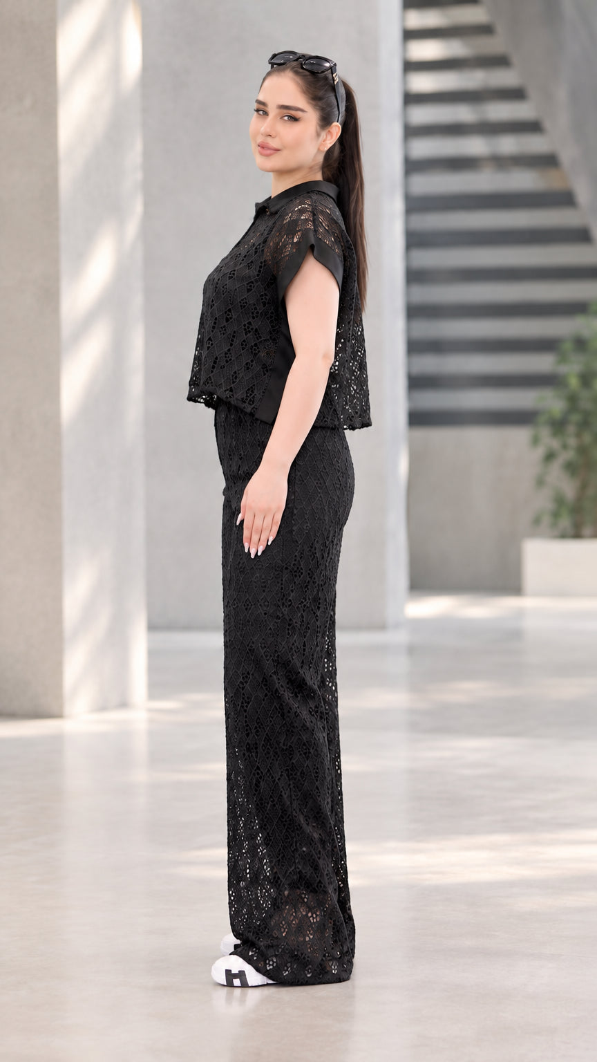 Side profile view of black lace two-piece top and wide-leg trousers set