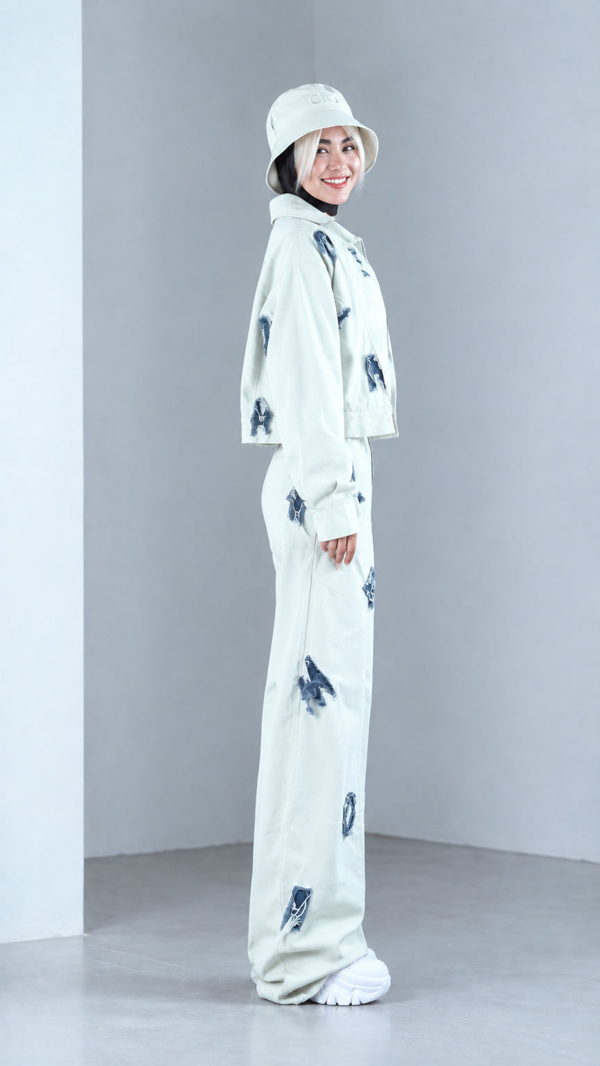 Side view of woman posing in mint green two-piece jacket and wide-leg streetwear set