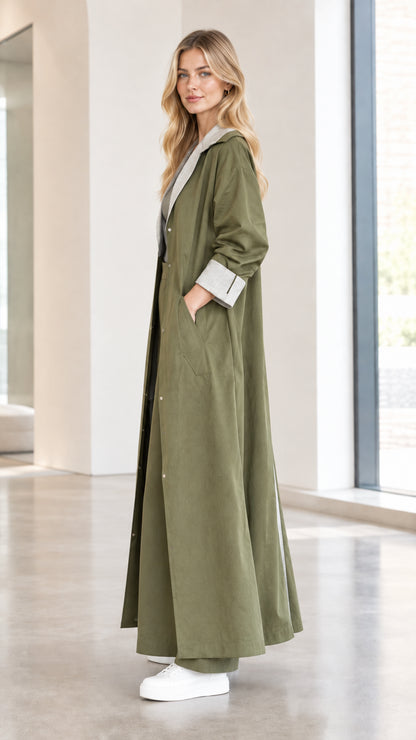 Side profile view of women wearing olive green floor-length duster coat