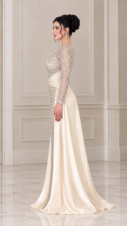 Side angle view of woman modeling the champagne embellished formal gown with dramatic train