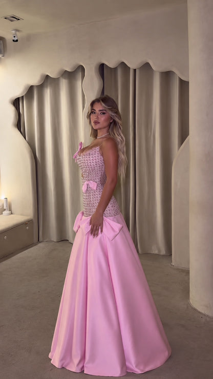 Side profile of pink crystal corset evening dress with flowing satin skirt