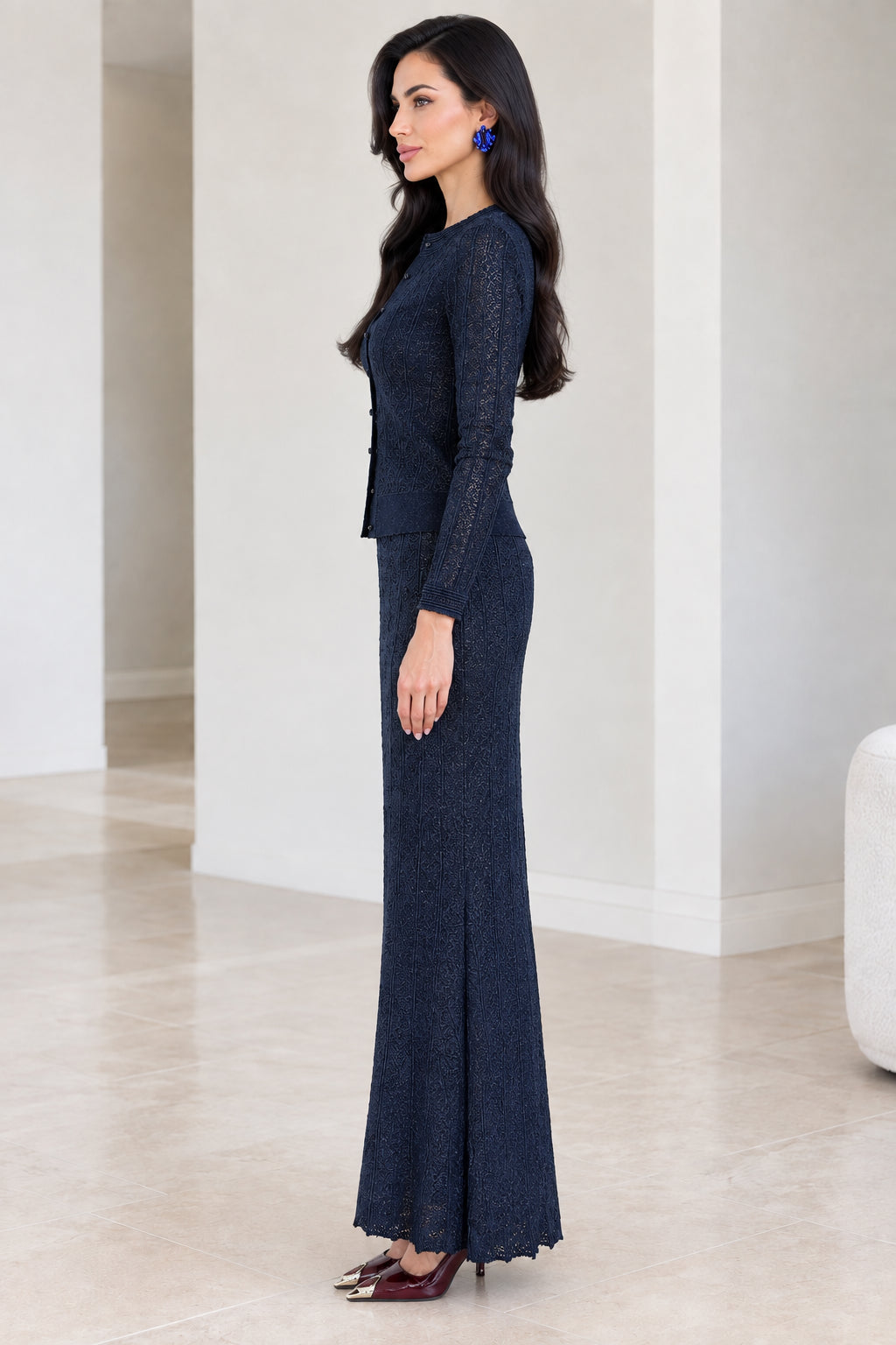 Side profile view of woman modeling navy blue knit two-piece maxi set