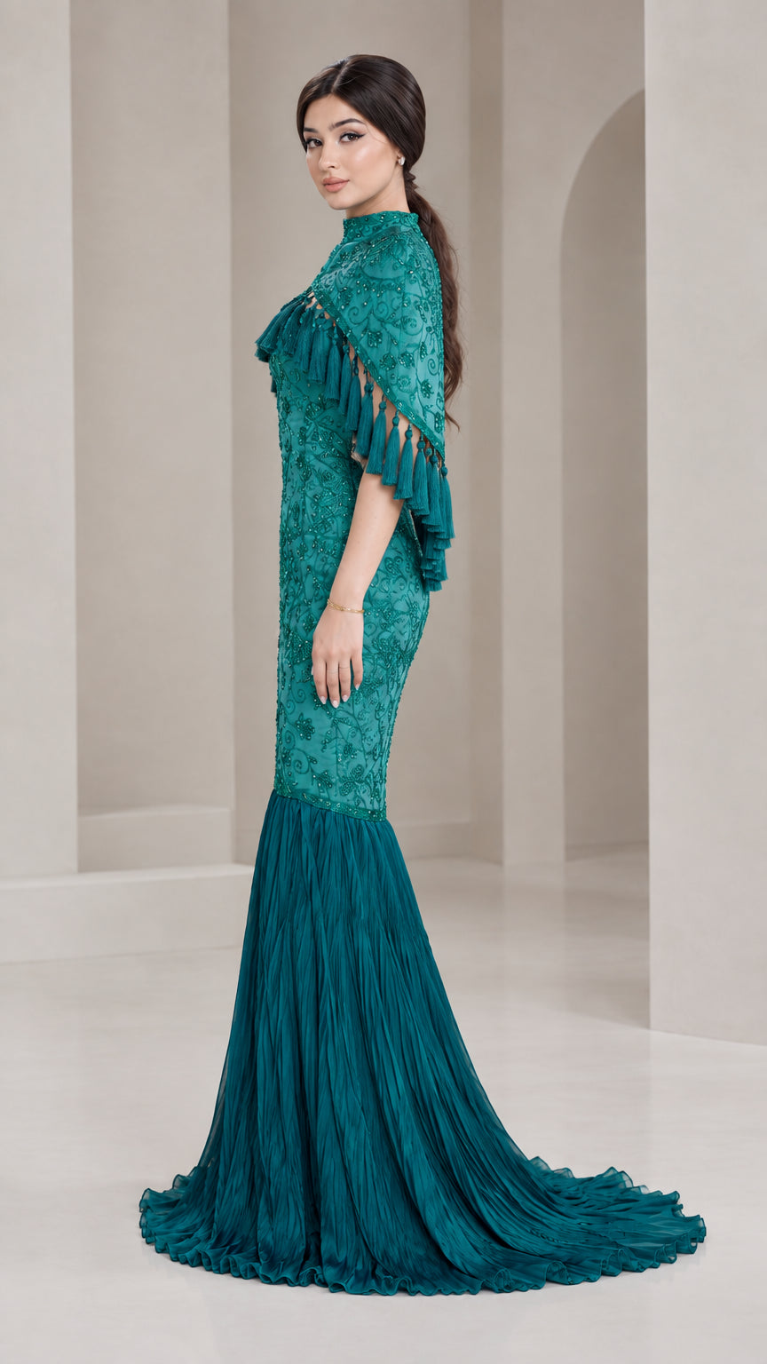 Side profile of model in Teal Green embellished cape maxi dress with flared mermaid train
