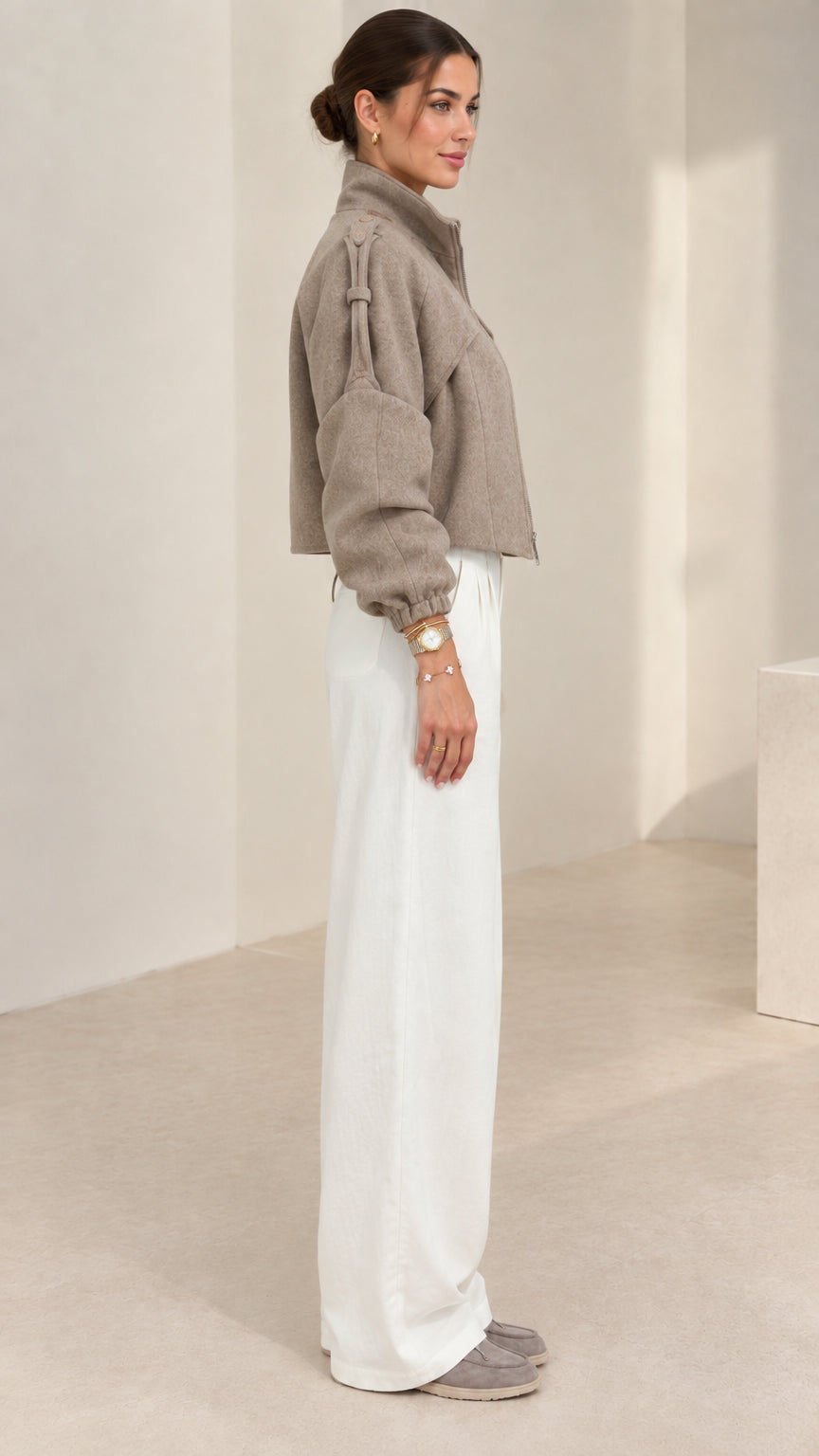Side profile view of taupe cropped short jacket showing sleeve volume and fit
