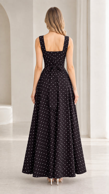 Back view of black polka dot dress showing square back and waist tie bow