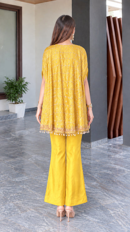 Back view of mustard yellow cape tunic and pants outfit