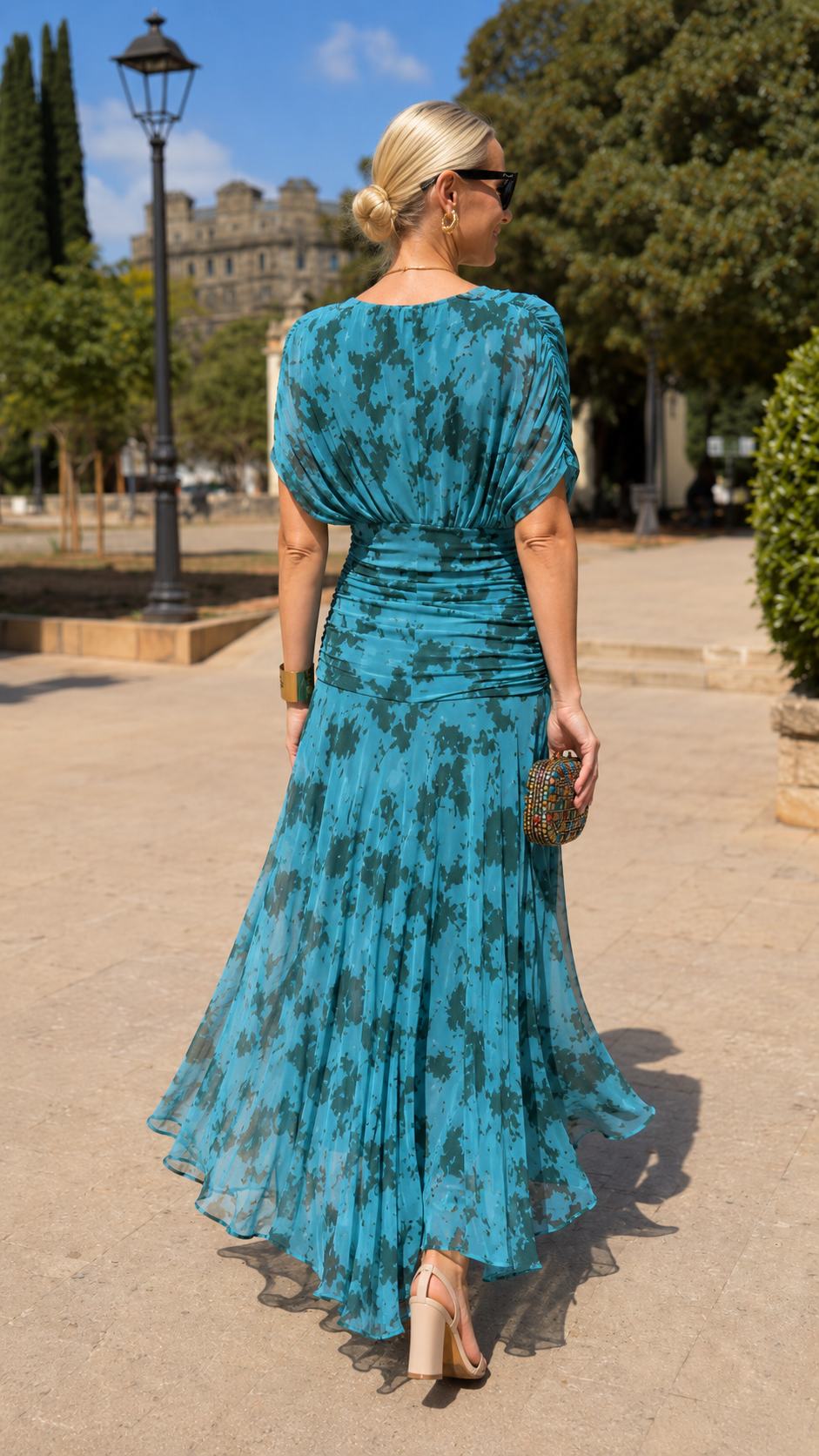 Back view of teal flowing pleated dress with ruched waist