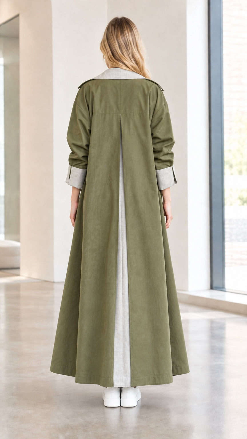 Back view of olive green maxi trench coat highlighting the inverted contrast back pleat