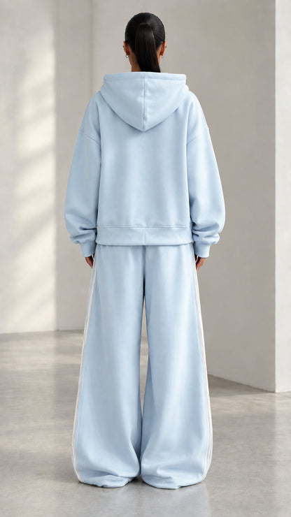 Back view of model wearing Light Blue hooded sweatshirt and matching wide-leg pants