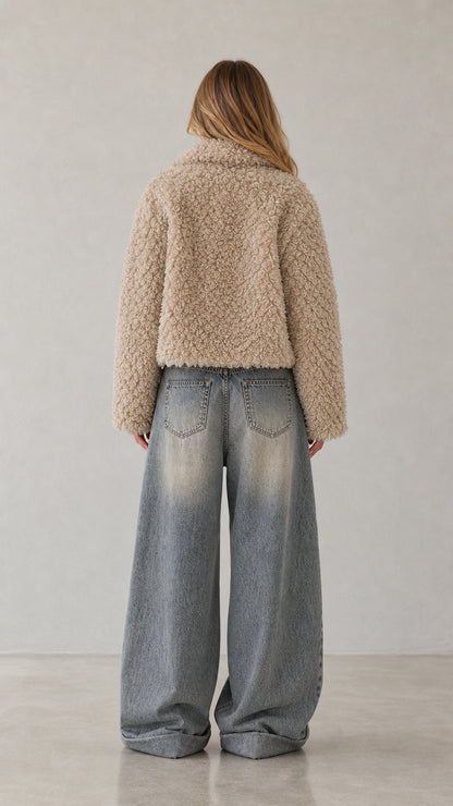 Back view of woman wearing beige cropped teddy fleece jacket