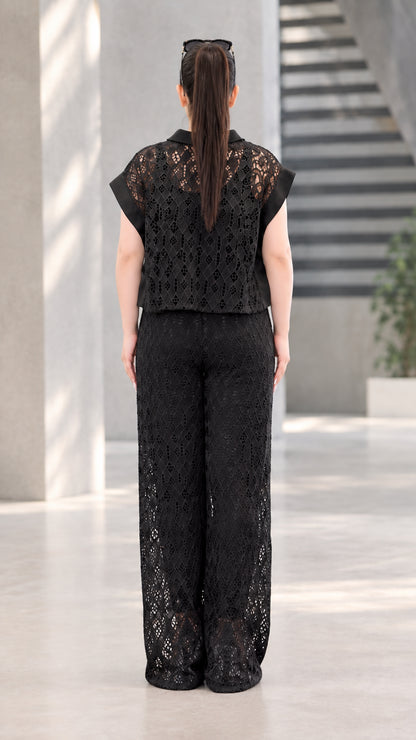 Back full-length view of black lace collared blouse and flowing wide-leg pants