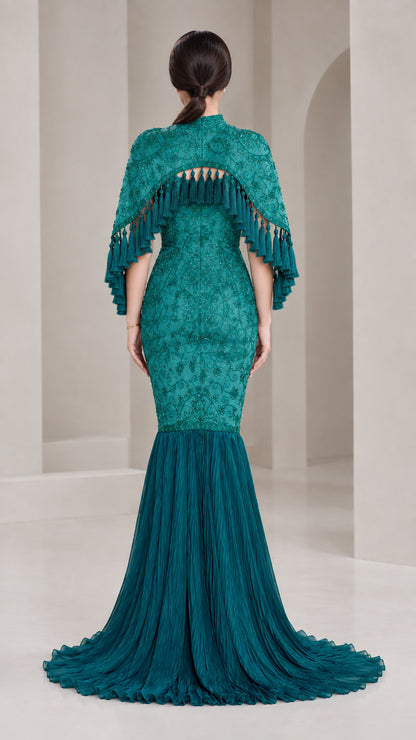Back view of model showing Teal Green embroidered capelet and flowing pleated skirt