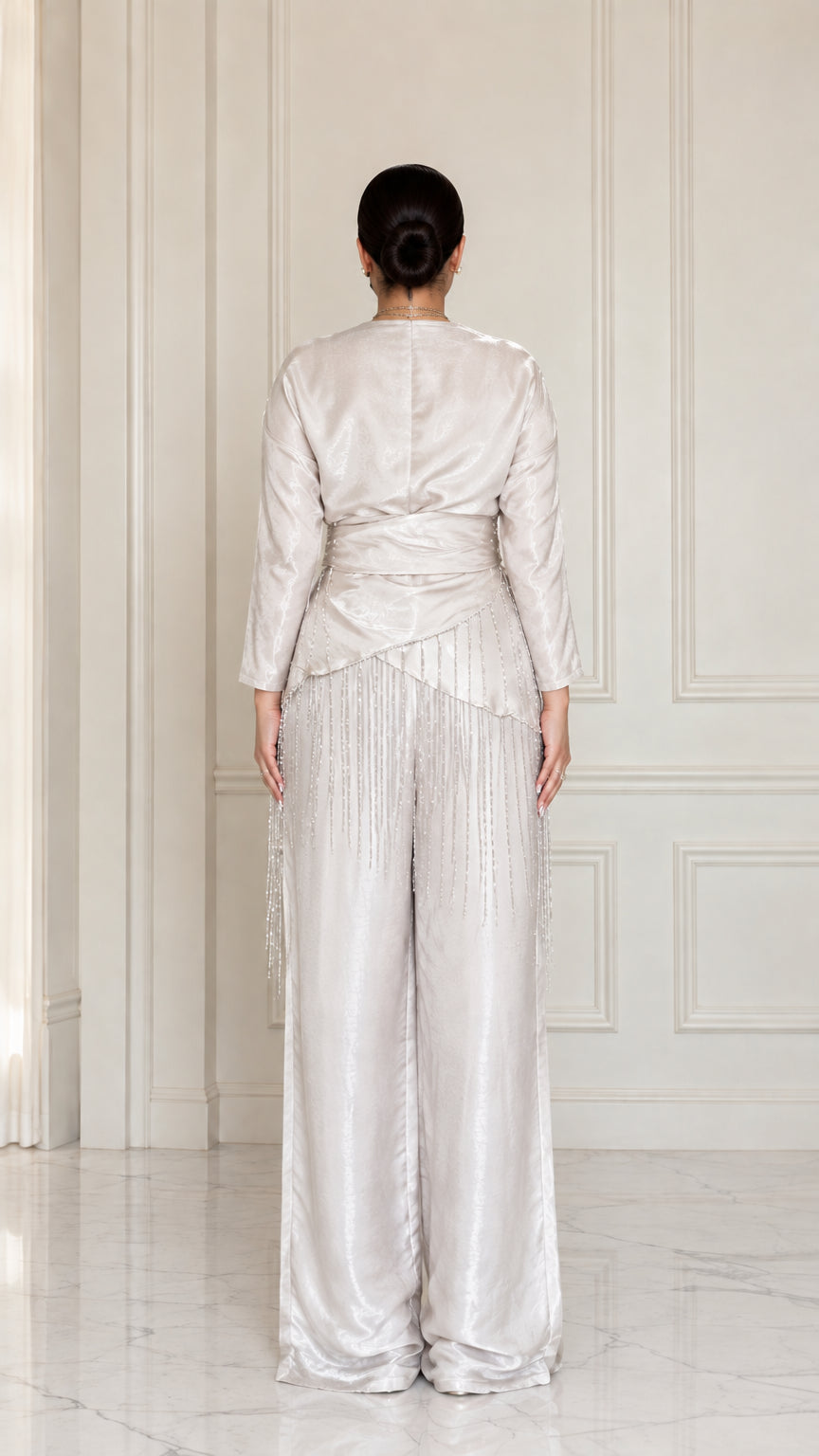 Back full view of model wearing Champagne satin draped blouse and trousers