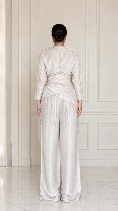Back full view of model wearing Champagne satin draped blouse and trousers