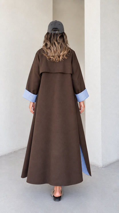 Back view of brown maxi trench coat highlighting classic storm flap construction