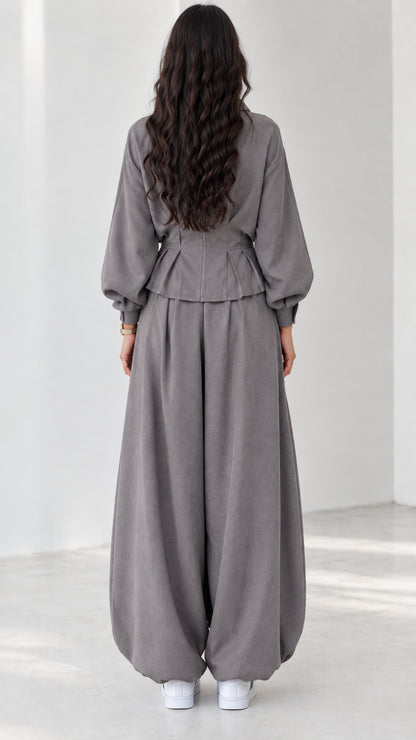 Back view of model in grey long-sleeve two-piece outfit with gathered waist and cuffs