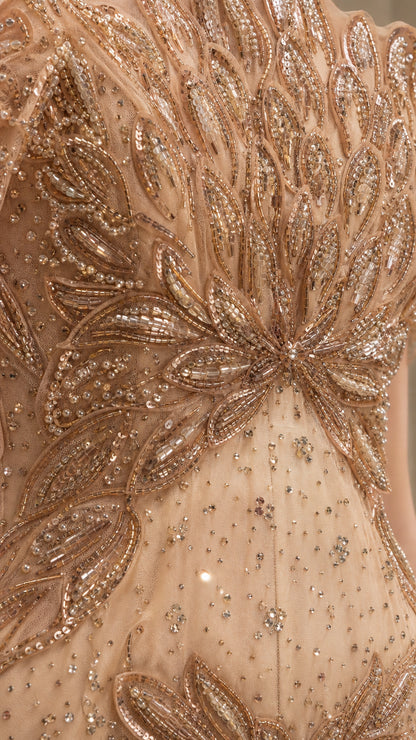 Detailed close-up of intricate gold floral beadwork, sequins, and crystal embellishments on sheer mesh