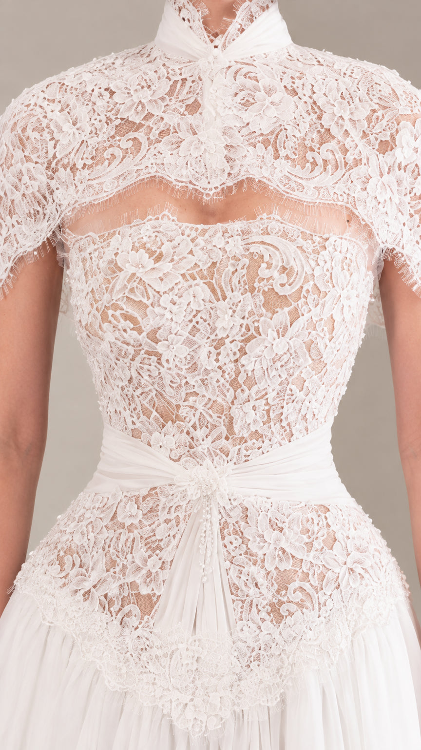 Close up of intricate floral lace bodice and capelet neckline