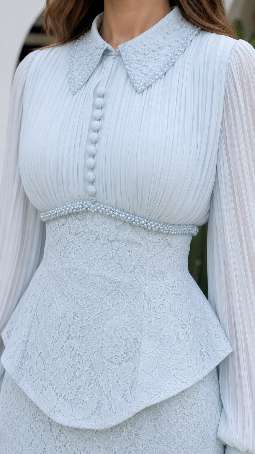 Close-up of embellished collar, pleated bodice, and beaded peplum waist