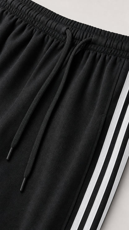 Close-up detail of black drawstring elastic waistband and side white stripes