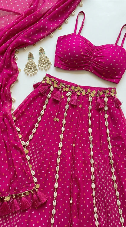 Close-up flat lay of hot pink bustier top with cowrie shell waistband trim