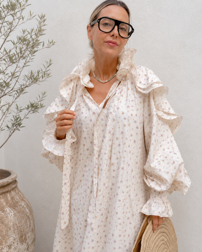 Close-up of ruffle collar tie neckline and floral print on cream midi dress