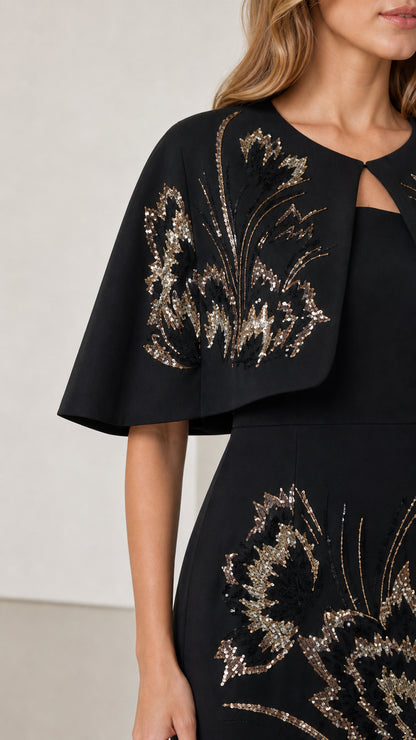 Close-up detail of shimmering gold floral sequin embroidery on black capelet