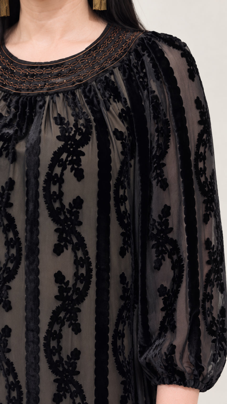 Close-up of embellished neckline and sheer burnout velvet sleeves