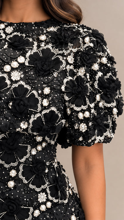 Close-up detail of 3D floral rosettes and faux pearl beadwork on bodice and sleeve