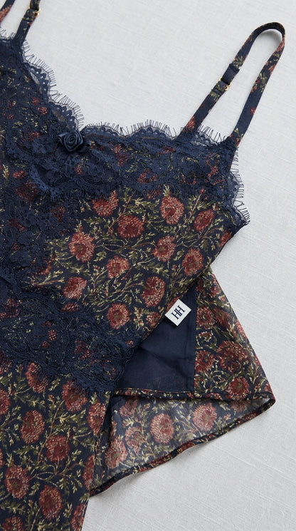Close-up detail of lace neckline, adjustable straps, and inner lining on navy dress