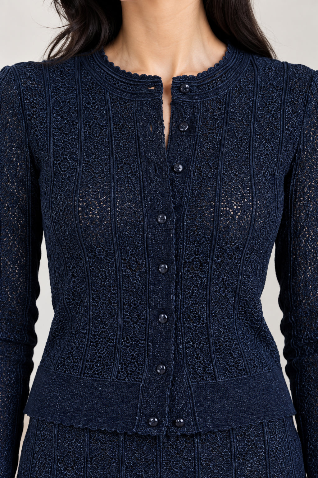 Close-up detail of navy blue knit button-down cardigan texture and neckline