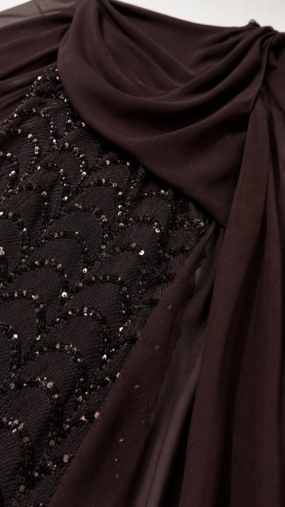 Close-up detail of shimmering scalloped sequin pattern and draped chiffon fabric in dark brown
