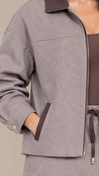 Close-up detail of textured jacket fabric, zipper, contrast collar, and pockets