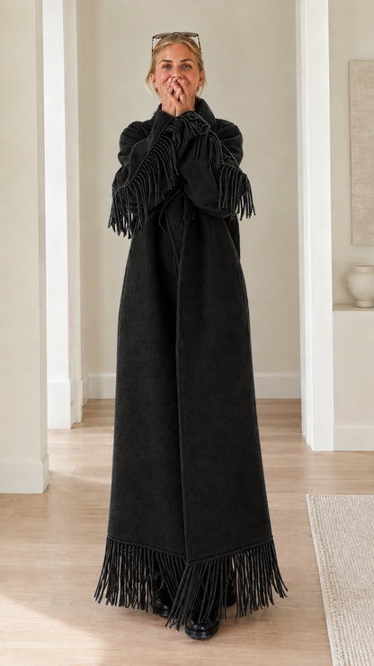 Full-length view of woman wearing black fringe trimmed maxi overcoat