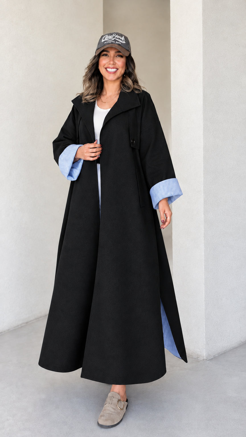 Full-length studio shot of woman wearing black maxi trench duster coat