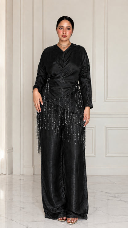 Full-length view of model wearing Black satin draped two-piece set with beaded trim