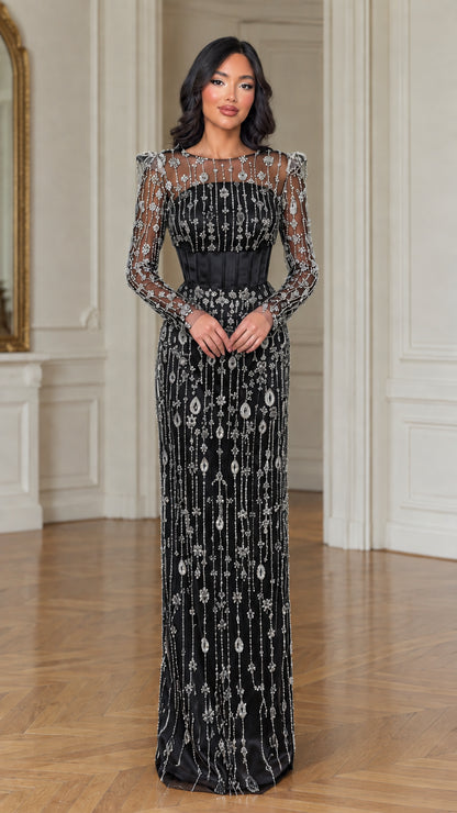 Model wearing black illusion beaded corset long sleeve evening dress