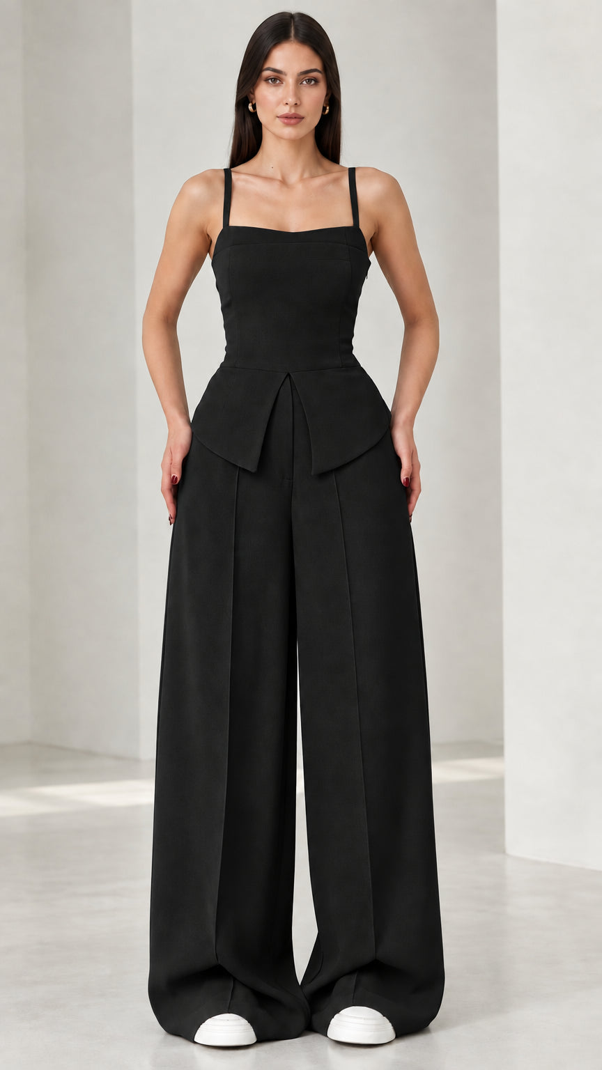 Full front view of model wearing black square neck peplum wide leg jumpsuit