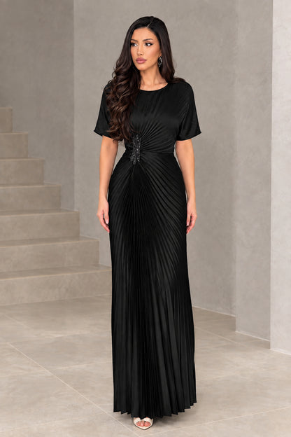Front full-length view of woman wearing black pleated short sleeve formal maxi dress